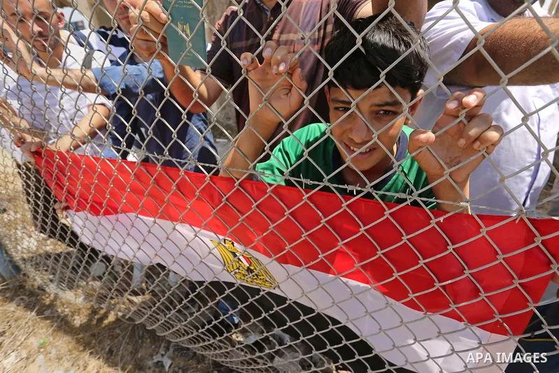 Palestinians gather in front of the gate of Rafah border crossing between Egypt and Gaza during a protest against the blockade calling for reopening of the crossing, in the southern Gaza Strip July 3, 2017. Photo by Ashr...