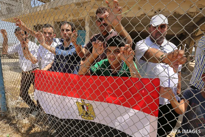 Palestinians gather in front of the gate of Rafah border crossing between Egypt and Gaza during a protest against the blockade calling for reopening of the crossing, in the southern Gaza Strip July 3, 2017. Photo by Ashr...