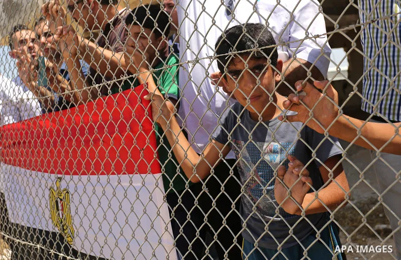 Palestinians gather in front of the gate of Rafah border crossing between Egypt and Gaza during a protest against the blockade calling for reopening of the crossing, in the southern Gaza Strip July 3, 2017. Photo by Ashr...