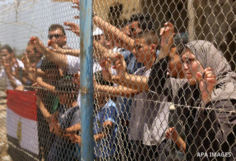 Palestinians gather in front of the gate of Rafah border crossing between Egypt and Gaza during a protest against the blockade calling for reopening of the crossing, in the southern Gaza Strip July 3, 2017. Photo by Ashr...