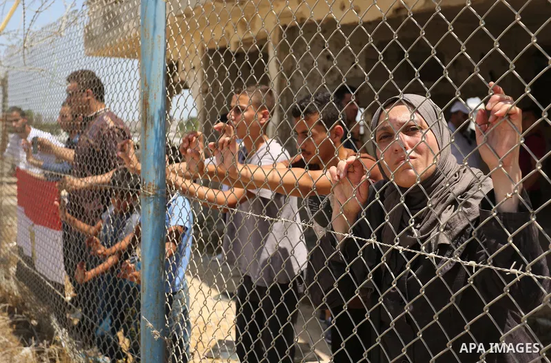 Palestinians gather in front of the gate of Rafah border crossing between Egypt and Gaza during a protest against the blockade calling for reopening of the crossing, in the southern Gaza Strip July 3, 2017. Photo by Ashr...