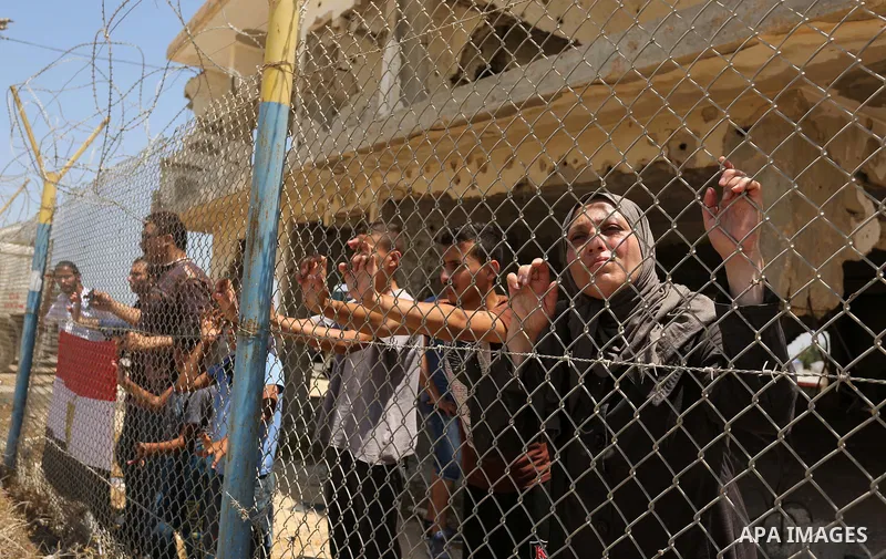 Palestinians gather in front of the gate of Rafah border crossing between Egypt and Gaza during a protest against the blockade calling for reopening of the crossing, in the southern Gaza Strip July 3, 2017. Photo by Ashr...