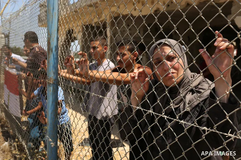Palestinians gather in front of the gate of Rafah border crossing between Egypt and Gaza during a protest against the blockade calling for reopening of the crossing, in the southern Gaza Strip July 3, 2017. Photo by Ashr...