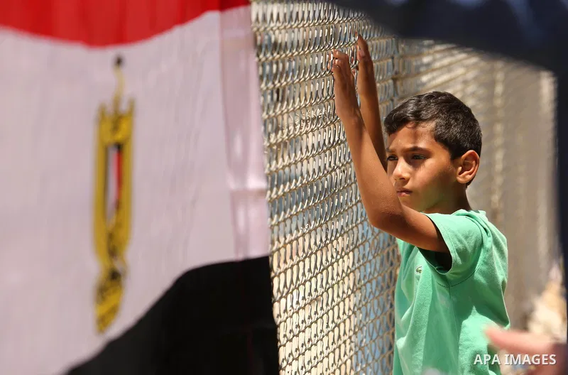 Palestinians gather in front of the gate of Rafah border crossing between Egypt and Gaza during a protest against the blockade calling for reopening of the crossing, in the southern Gaza Strip July 3, 2017. Photo by Ashr...