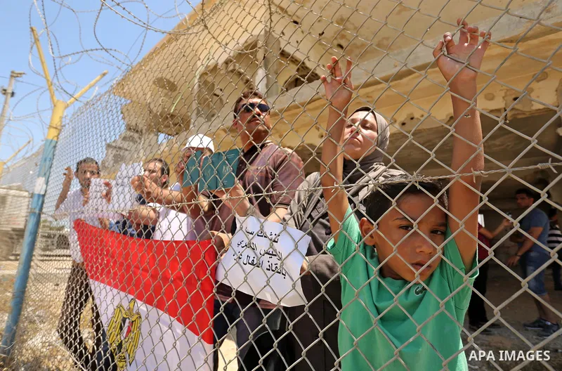 Palestinians gather in front of the gate of Rafah border crossing between Egypt and Gaza during a protest against the blockade calling for reopening of the crossing, in the southern Gaza Strip July 3, 2017. Photo by Ashr...
