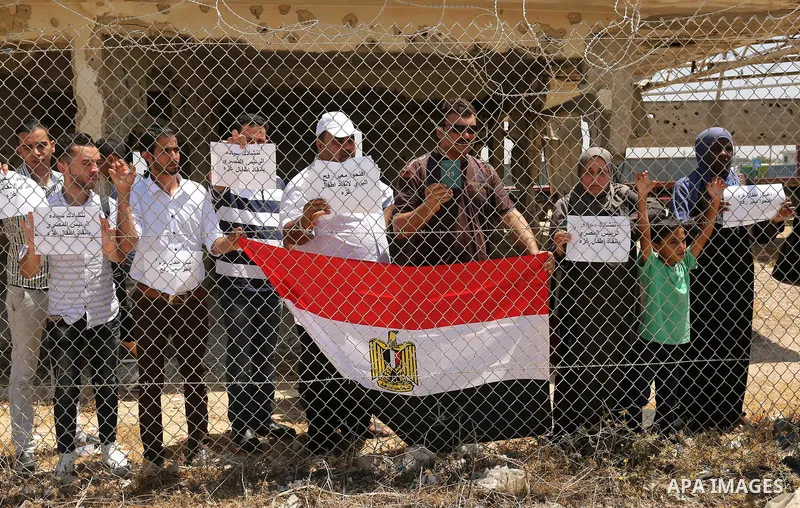 Palestinians gather in front of the gate of Rafah border crossing between Egypt and Gaza during a protest against the blockade calling for reopening of the crossing, in the southern Gaza Strip July 3, 2017. Photo by Ashr...