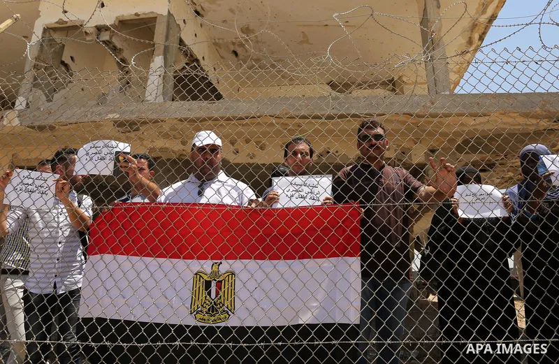 Palestinians gather in front of the gate of Rafah border crossing between Egypt and Gaza during a protest against the blockade calling for reopening of the crossing, in the southern Gaza Strip July 3, 2017. Photo by Ashr...