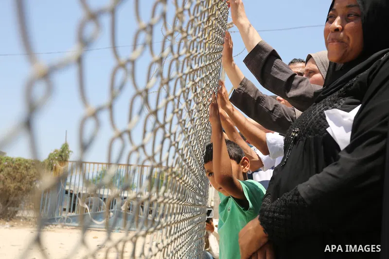Palestinians gather in front of the gate of Rafah border crossing between Egypt and Gaza during a protest against the blockade calling for reopening of the crossing, in the southern Gaza Strip July 3, 2017. Photo by Ashr...