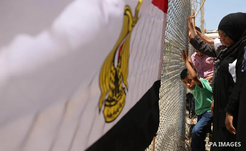 Palestinians gather in front of the gate of Rafah border crossing between Egypt and Gaza during a protest against the blockade calling for reopening of the crossing, in the southern Gaza Strip July 3, 2017. Photo by Ashr...