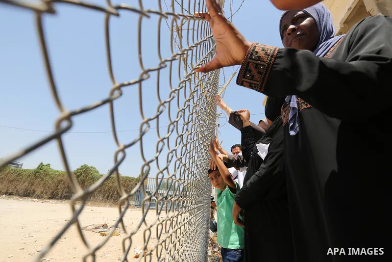 Palestinians gather in front of the gate of Rafah border crossing between Egypt and Gaza during a protest against the blockade calling for reopening of the crossing, in the southern Gaza Strip July 3, 2017. Photo by Ashr...