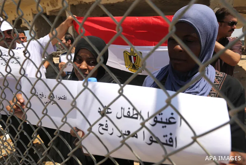 Palestinians gather in front of the gate of Rafah border crossing between Egypt and Gaza during a protest against the blockade calling for reopening of the crossing, in the southern Gaza Strip July 3, 2017. Photo by Ashr...