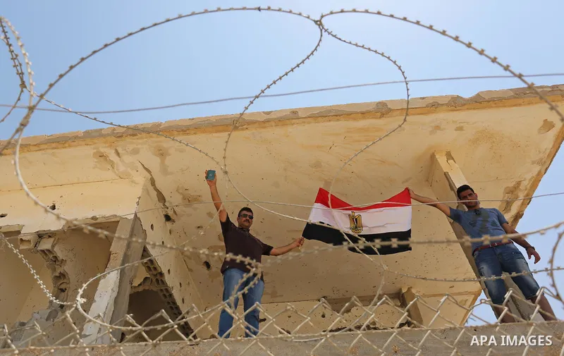 Palestinians gather in front of the gate of Rafah border crossing between Egypt and Gaza during a protest against the blockade calling for reopening of the crossing, in the southern Gaza Strip July 3, 2017. Photo by Ashr...