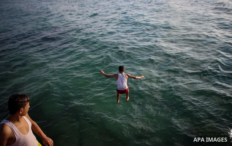 Palestinians swim in the Mediterranean sea on the coast of Gaza city during a hot day on July 3, 2017. Photo by Majd Hajjar