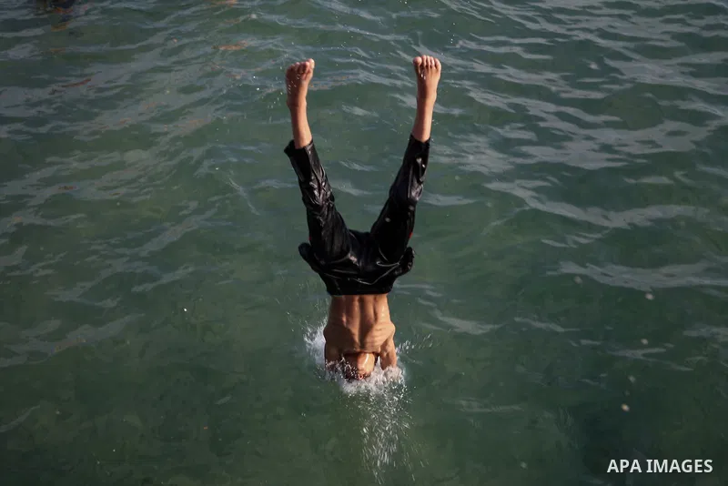 A Palestinian boy swims in the Mediterranean sea on the coast of Gaza city during a hot day on July 3, 2017. Photo by Majd Hajjar