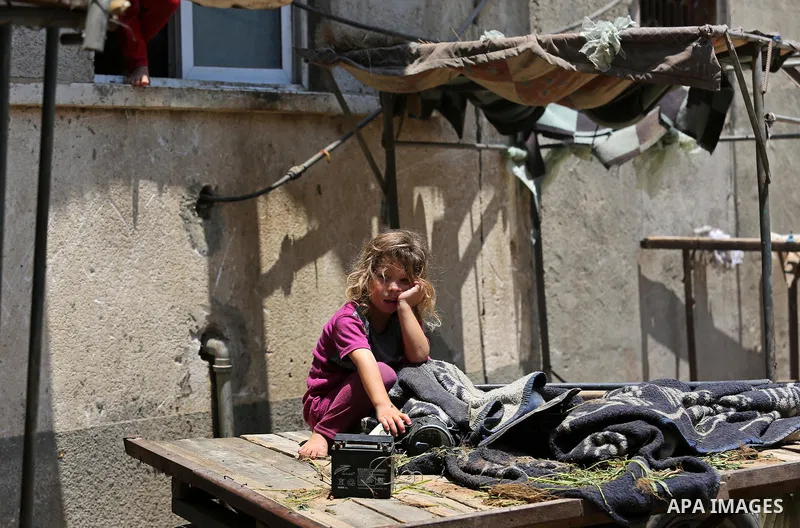 A Palestinian girl stands outside her family house during a heatwave in Beit Lahia in the northern of Gaza Strip, on July 4, 2017. Photo by Ashraf Amra