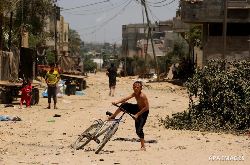 A Palestinian boy rides his bicycle at street during a heatwave in Beit Lahia in the northern of Gaza Strip, on July 4, 2017. Photo by Ashraf Amra