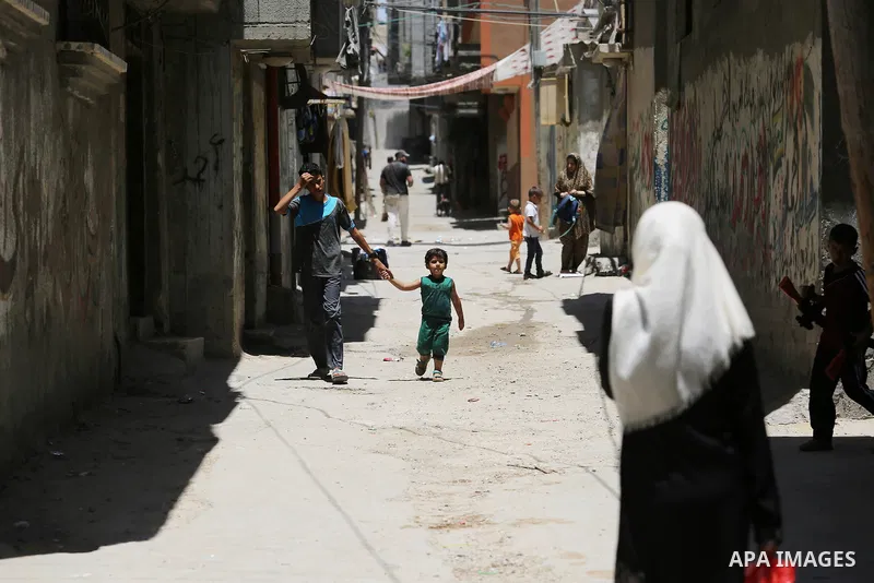 Palestinians walk at street during a heatwave in Beit Lahia in the northern of Gaza Strip, on July 4, 2017. Photo by Ashraf Amra
