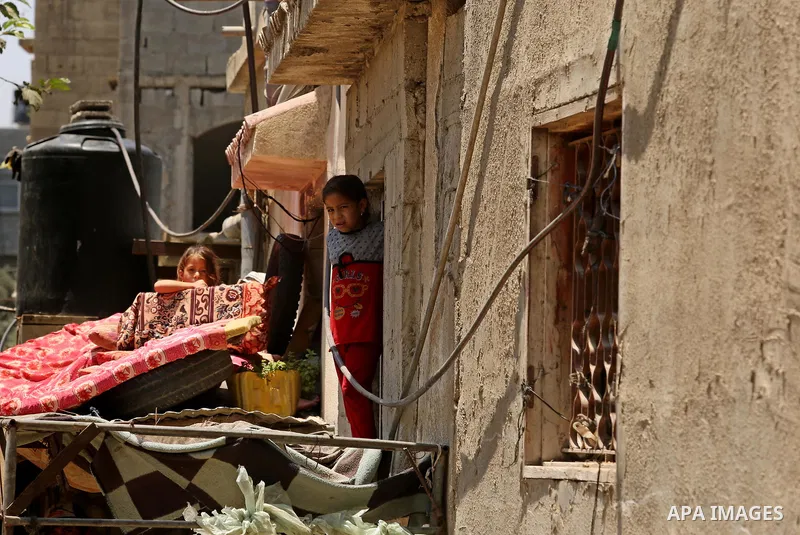 Palestinian girls stand outside their family house during a heatwave in Beit Lahia in the northern of Gaza Strip, on July 4, 2017. Photo by Ashraf Amra