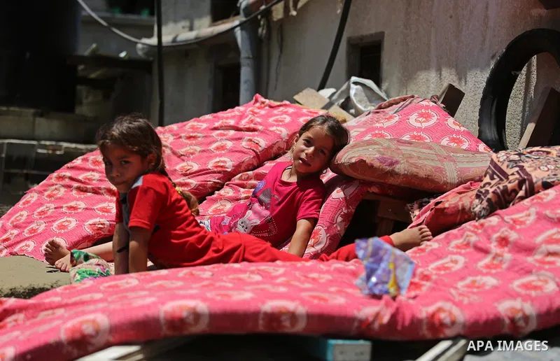 Palestinian girls stand outside their family house during a heatwave in Beit Lahia in the northern of Gaza Strip, on July 4, 2017. Photo by Ashraf Amra