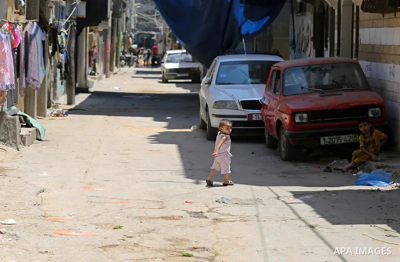 A Palestinian child crosses the street during a heatwave in Beit Lahia in the northern of Gaza Strip, on July 4, 2017. Photo by Ashraf Amra