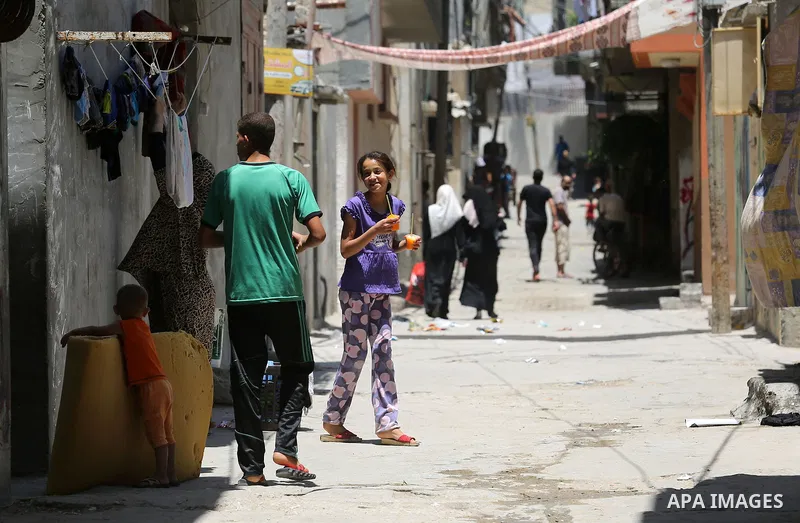 Palestinians walk at street during a heatwave in Beit Lahia in the northern of Gaza Strip, on July 4, 2017. Photo by Ashraf Amra