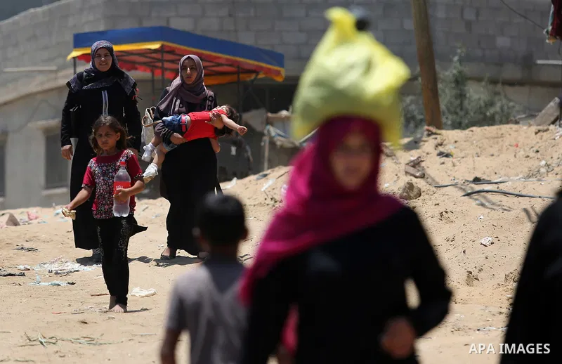 Palestinians walk at street during a heatwave in Beit Lahia in the northern of Gaza Strip, on July 4, 2017. Photo by Ashraf Amra