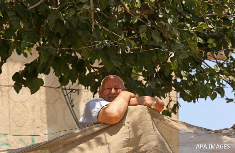 A Palestinian man stands at his house during a heatwave in Beit Lahia in the northern of Gaza Strip, on July 4, 2017. Photo by Ashraf Amra