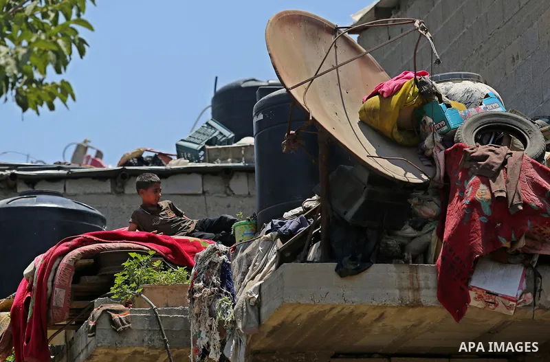 A Palestinian boy lies down on the roof of his family house during a heatwave in Beit Lahia in the northern of Gaza Strip, on July 4, 2017. Photo by Ashraf Amra