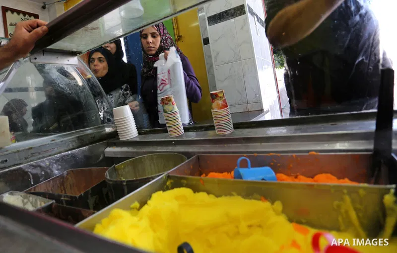 Palestinians buy ice-cream (sundae) during a heatwave in Gaza city on July 4, 2017. Photo by Ashraf Amra