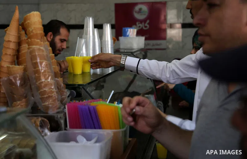 Palestinians buy ice-cream (sundae) during a heatwave in Gaza city on July 4, 2017. Photo by Ashraf Amra
