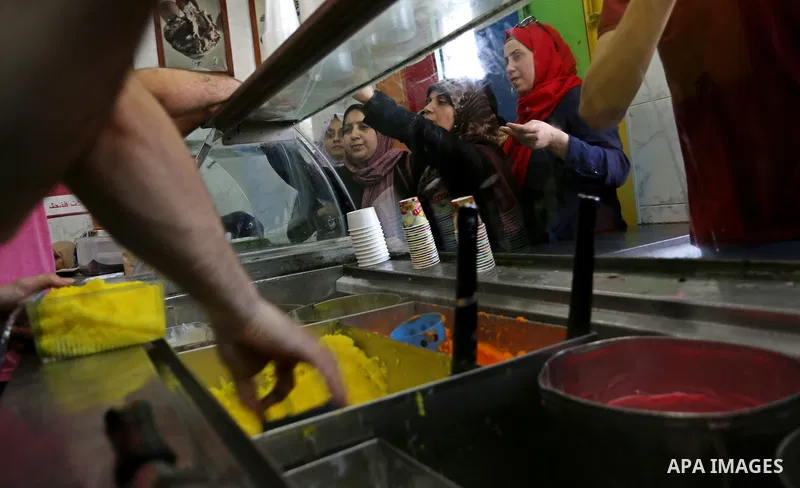 Palestinians buy ice-cream (sundae) during a heatwave in Gaza city on July 4, 2017. Photo by Ashraf Amra