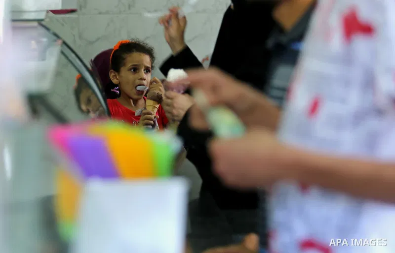 A Palestinians girl eats ice-cream (sundae) during a heatwave in Gaza city on July 4, 2017. Photo by Ashraf Amra