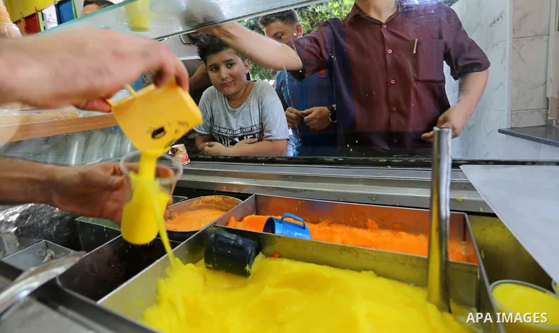 Palestinians buy ice-cream (sundae) during a heatwave in Gaza city on July 4, 2017. Photo by Ashraf Amra