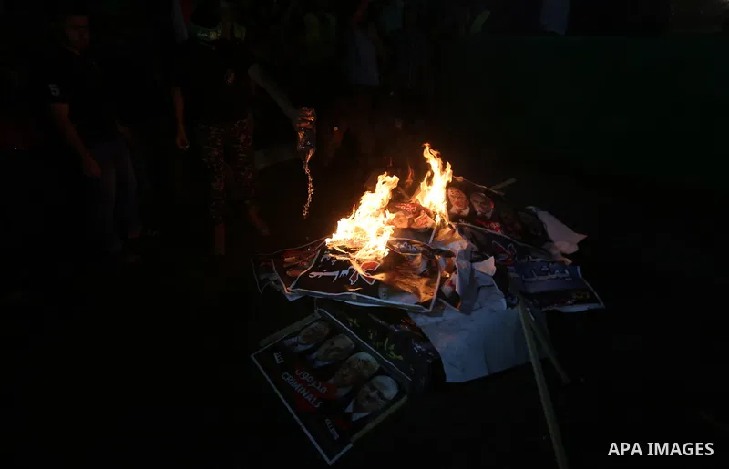 Palestinians burn a poster of Palestinian President Mahmoud Abbas during a protest, in Gaza city, on July 4, 2017. Photo by Mohammed Asad