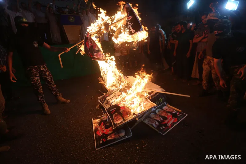 Palestinians burn a poster of Palestinian President Mahmoud Abbas during a protest, in Gaza city, on July 4, 2017. Photo by Mohammed Asad