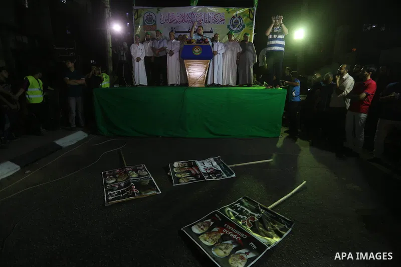Palestinians hold banners during a protest against Palestinian President Mahmoud Abbas and Israeli blockade of the Gaza Strip, in Gaza city, on July 4, 2017. Photo by Mohammed Asad