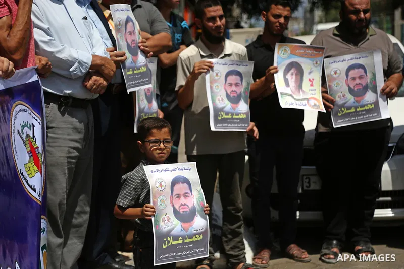Palestinian supporters of the Islamic Jihad Movement, hold placards during a protest to show solidarity with Palestinian prisoners held in Israeli Jails, in Gaza city, on July 5, 2017. Photo by Ashraf Amra