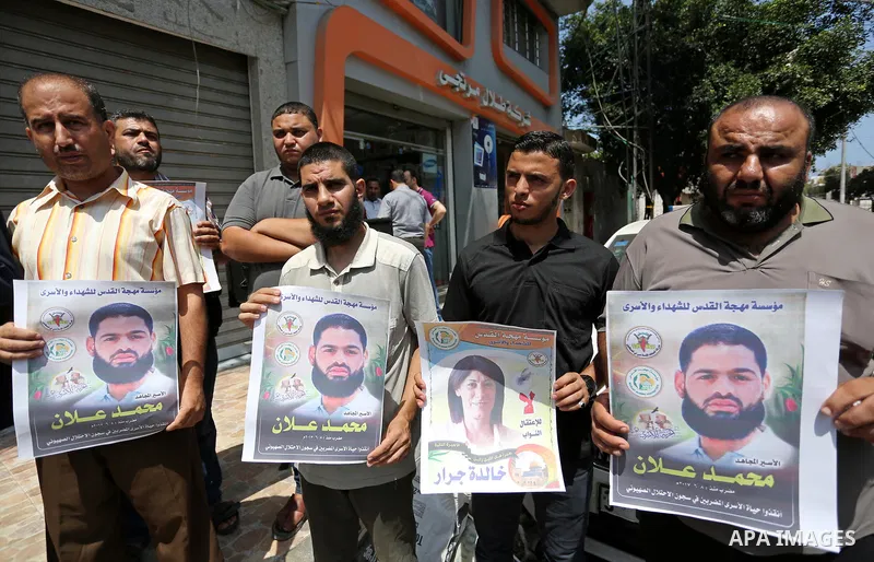 Palestinian supporters of the Islamic Jihad Movement, hold placards during a protest to show solidarity with Palestinian prisoners held in Israeli Jails, in Gaza city, on July 5, 2017. Photo by Ashraf Amra