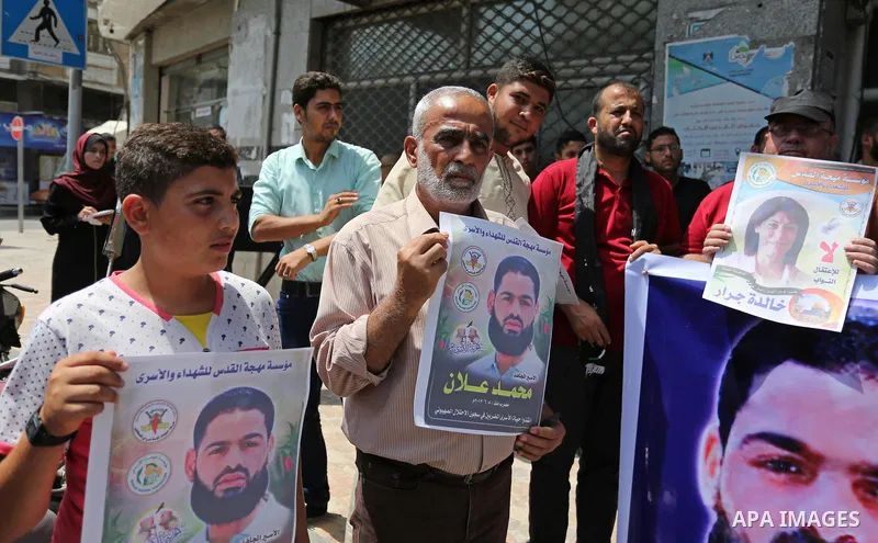 Palestinian supporters of the Islamic Jihad Movement, hold placards during a protest to show solidarity with Palestinian prisoners held in Israeli Jails, in Gaza city, on July 5, 2017. Photo by Ashraf Amra