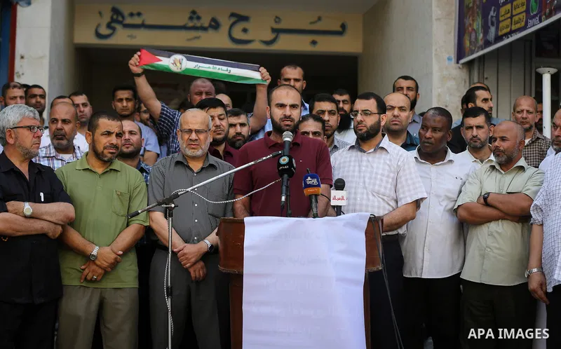 Palestinians take part in a protest demanding their salaries in Gaza city on July 5, 2017. Photo by Ashraf Amra