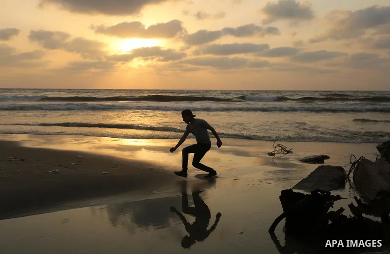 A Palestinian youth jumps on sewage in front of the coast of Gaza city, in July 5, 2017. An immediate consequence of the electricity cuts has been suffering for Gazans. A new U.N. report said Gaza gets electricity just f...