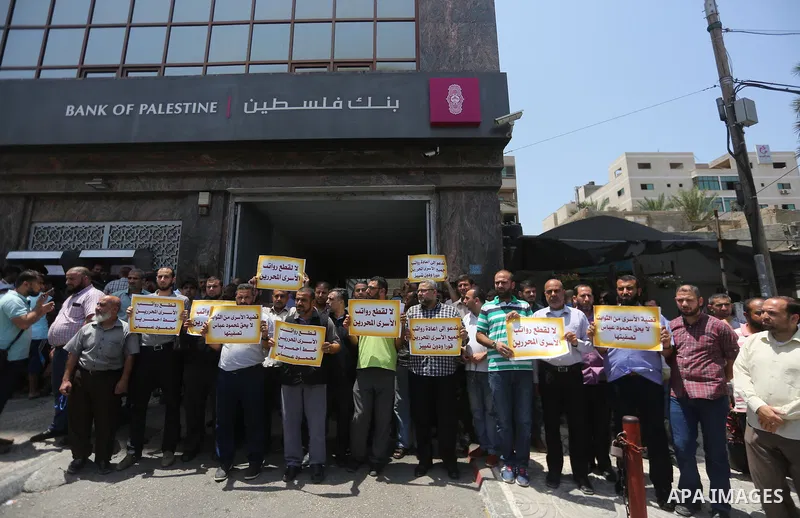 Palestinians take part in a protest demanding their salaries in Gaza city on July 6, 2017. Photo by Mohammed Asad