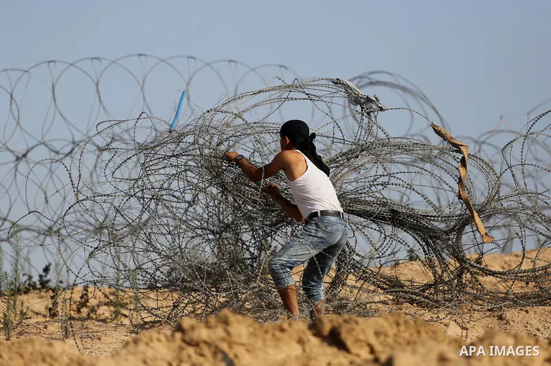 A Palestinian protester clashes with Israeli security forces near the border between Israel and Central Gaza Strip July 7, 2017. Photo by Ashraf Amra