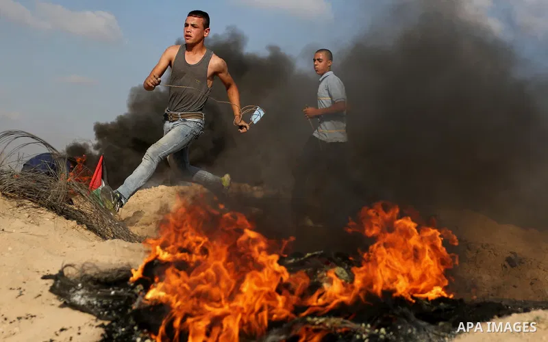 Palestinian protesters run for cover during clashes with Israeli security forces near the border between Israel and Central Gaza Strip July 7, 2017. Photo by Ashraf Amra