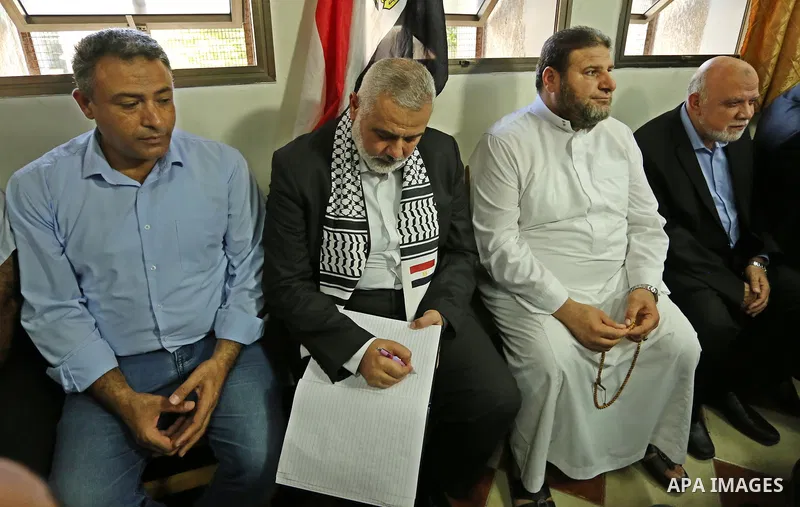 Hamas leader Ismail Haniya (C) signs a guest-book as he visits a mourning tent in Gaza City on July 8, 2017 set up for people to pay their respects to the Egyptian soldiers, who were killed a day earlier in the restive S...