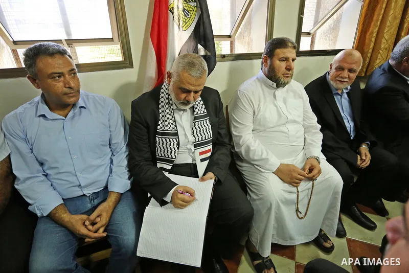 Hamas leader Ismail Haniya (C) signs a guest-book as he visits a mourning tent in Gaza City on July 8, 2017 set up for people to pay their respects to the Egyptian soldiers, who were killed a day earlier in the restive S...