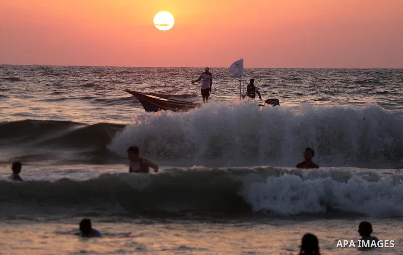Palestinians ride their boat in the Mediterranean sea on the coast of Gaza city during sunset on July 8, 2017. Photo by Mohammed Asad