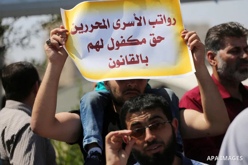 Palestinian released prisoners from Israeli jails hold placards during a protest demanding their salaries in Gaza city on July 9, 2017. Photo by Mohammed Asad
