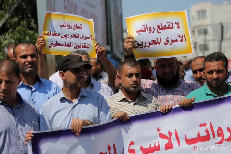 Palestinian released prisoners from Israeli jails hold placards during a protest demanding their salaries in Gaza city on July 9, 2017. Photo by Mohammed Asad