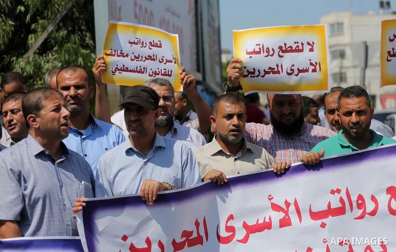 Palestinian released prisoners from Israeli jails hold placards during a protest demanding their salaries in Gaza city on July 9, 2017. Photo by Mohammed Asad